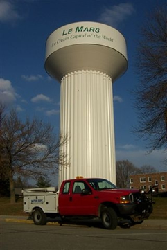 Le Mars Ice Cream Captial of the World water tower with a department truck parked in front of it and